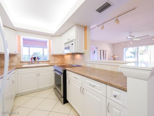 kitchen with a healthy amount of sunlight, sink, white appliances, and white cabinets