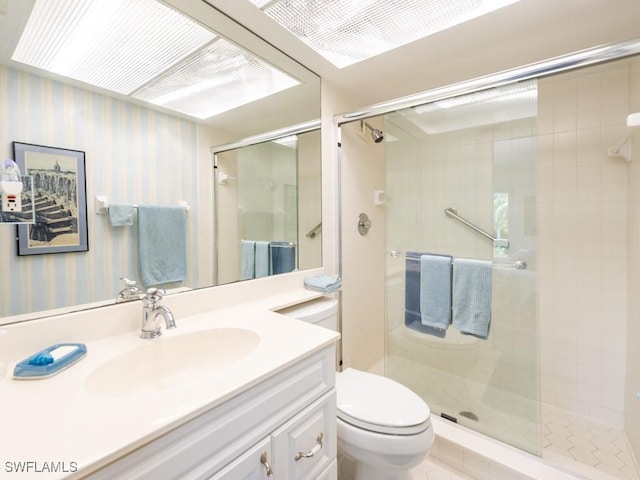 bathroom featuring vanity, toilet, and a shower with door