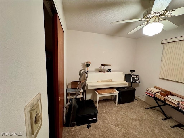 misc room with a textured ceiling, light colored carpet, and ceiling fan