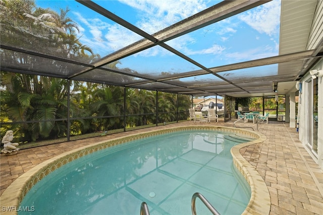 view of pool with a patio area and glass enclosure