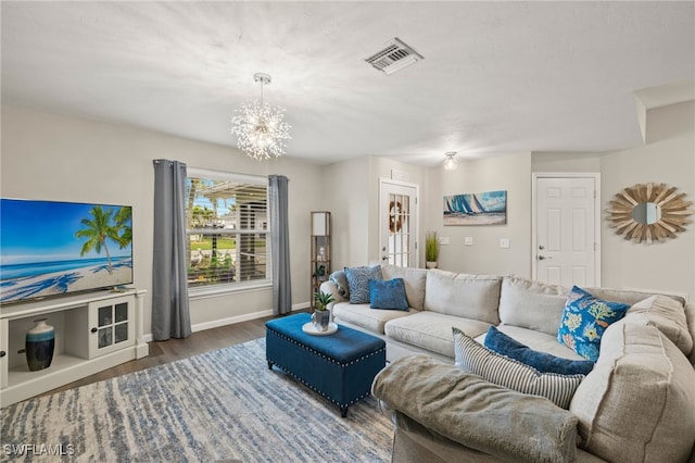 living room with dark hardwood / wood-style flooring and a chandelier