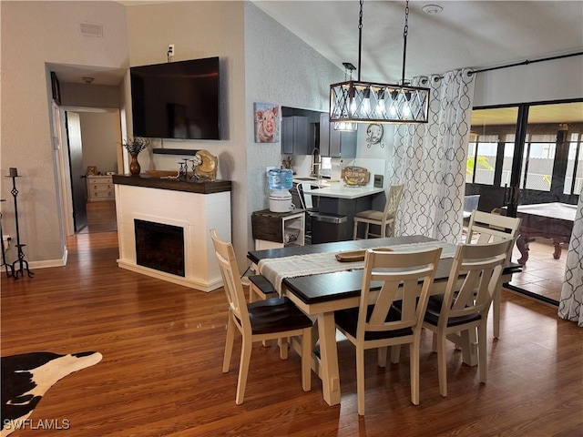 dining room featuring sink, dark hardwood / wood-style floors, and vaulted ceiling