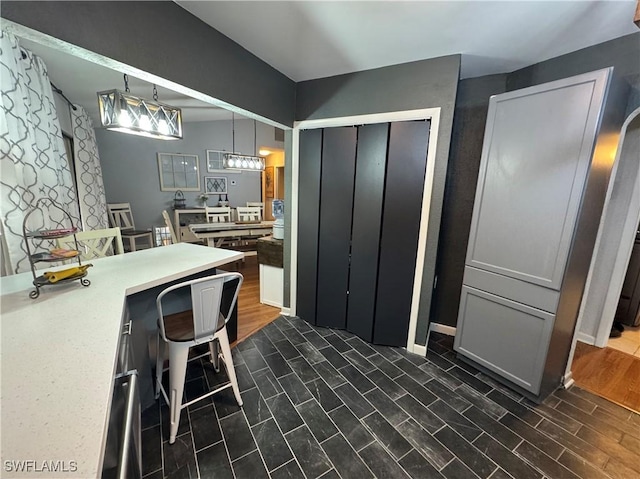 kitchen featuring pendant lighting, gray cabinetry, and a breakfast bar