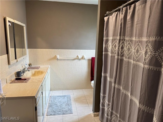 bathroom featuring tile walls, vanity, tile patterned floors, and toilet