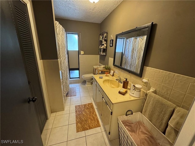 bathroom with tile walls, tile patterned floors, a textured ceiling, and toilet