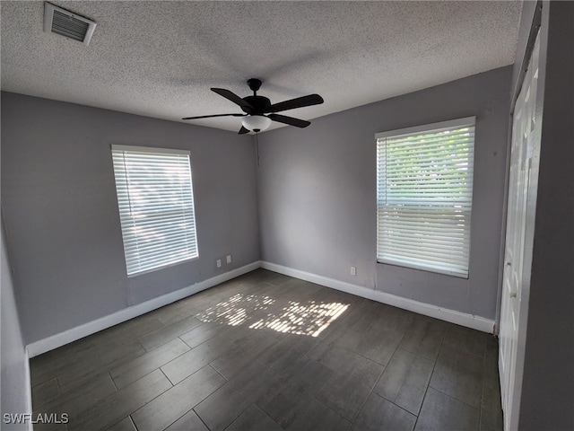 empty room featuring ceiling fan and a textured ceiling