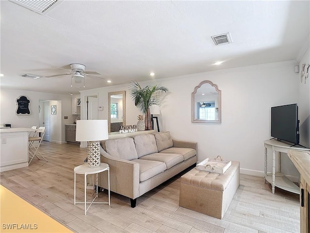 living room with light hardwood / wood-style flooring, ceiling fan, and ornamental molding