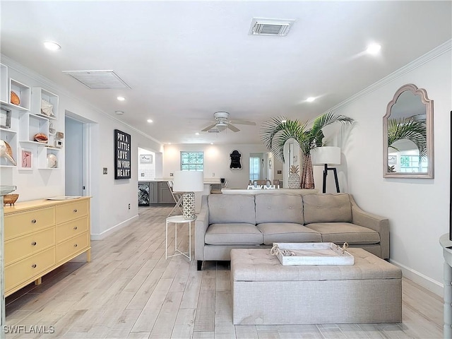 living room with ceiling fan, crown molding, and light hardwood / wood-style floors