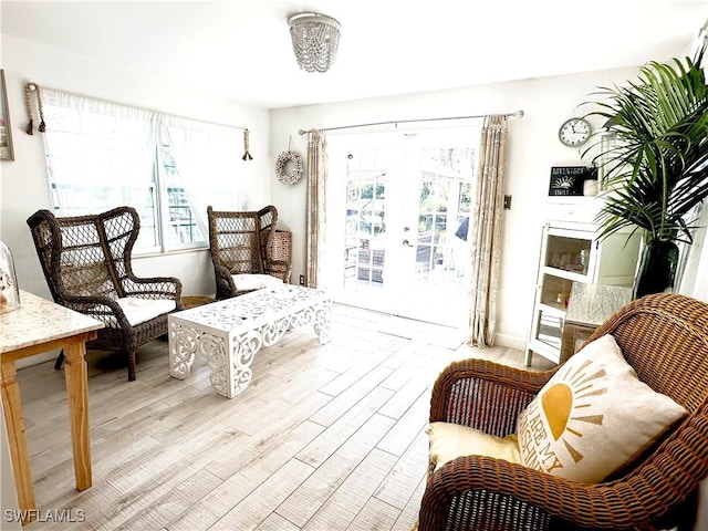 sitting room featuring light hardwood / wood-style floors, plenty of natural light, and french doors