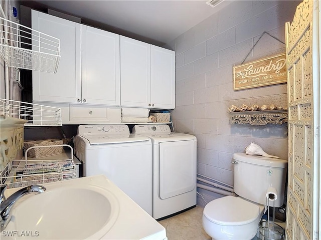 washroom featuring sink, washing machine and clothes dryer, and light tile patterned floors