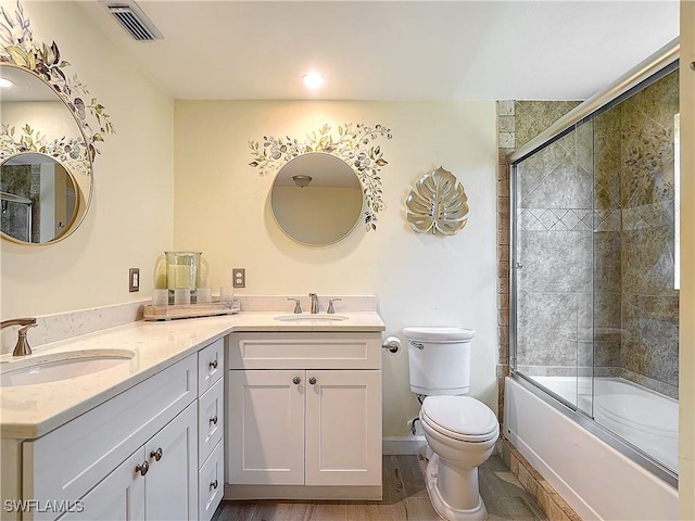 full bathroom featuring vanity, toilet, and bath / shower combo with glass door