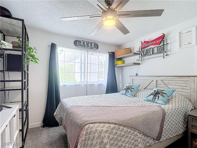 carpeted bedroom featuring ceiling fan and a textured ceiling