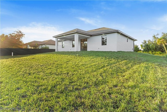 back of house with a lawn