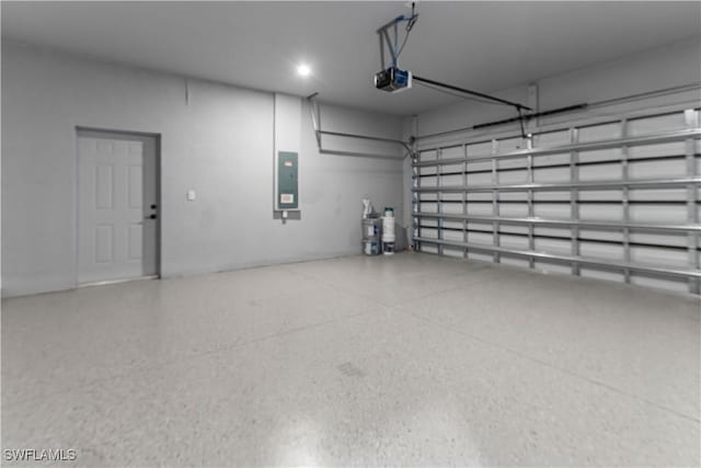 garage with a garage door opener and electric panel