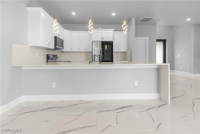 kitchen featuring stainless steel appliances, kitchen peninsula, white cabinets, and decorative light fixtures