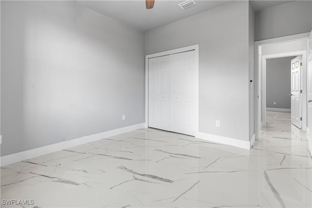 unfurnished bedroom with ceiling fan and a closet