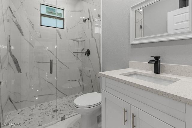 bathroom with toilet, vanity, and walk in shower