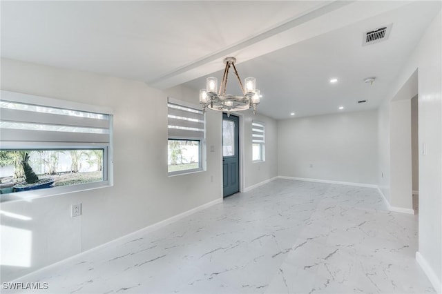 unfurnished room with a chandelier