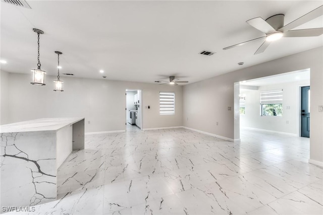 unfurnished room with washer and dryer and ceiling fan