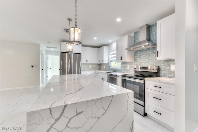 kitchen with light stone countertops, wall chimney range hood, white cabinets, and stainless steel appliances