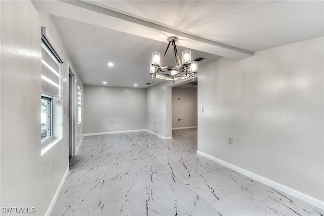 spare room featuring an inviting chandelier