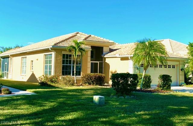 rear view of house with a yard and a garage