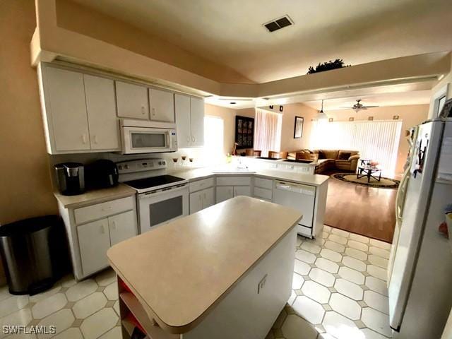 kitchen with ceiling fan, white appliances, kitchen peninsula, and white cabinets