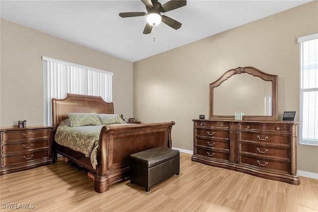 bedroom featuring baseboards, light wood-type flooring, and a ceiling fan