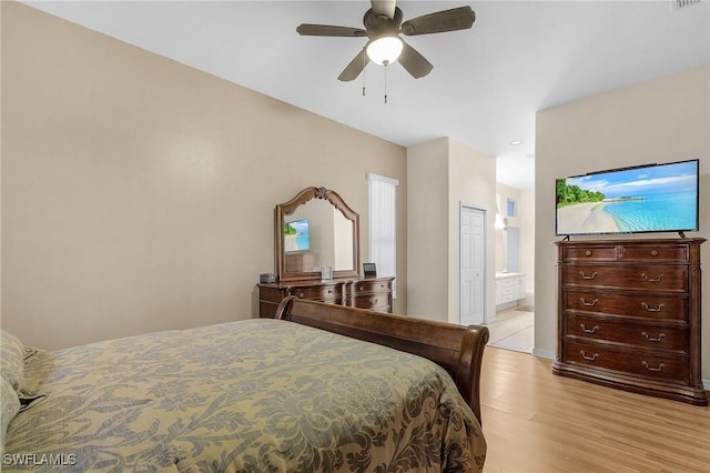 bedroom with ensuite bath, light wood-style floors, visible vents, and ceiling fan