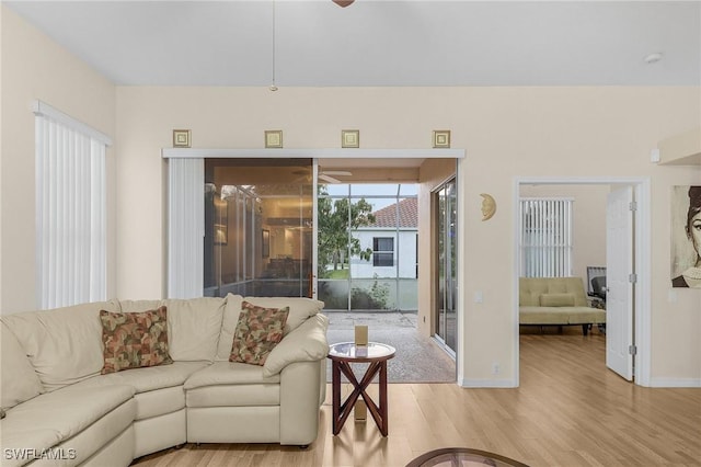 living area with light wood finished floors, baseboards, and ceiling fan