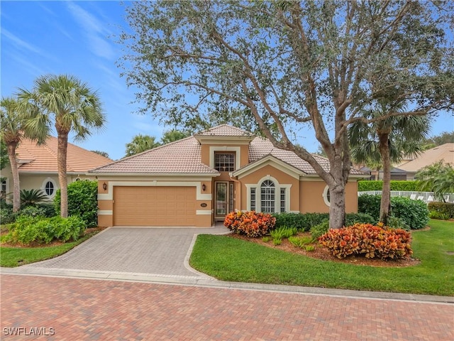 mediterranean / spanish home with a garage and a front yard