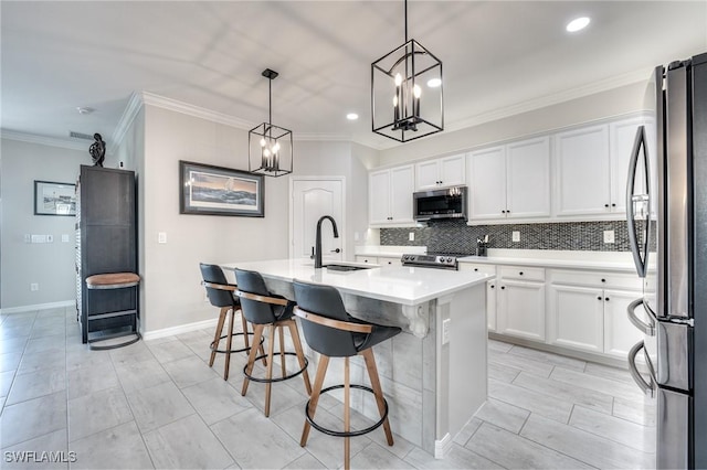 kitchen with sink, white cabinetry, hanging light fixtures, stainless steel appliances, and a center island with sink