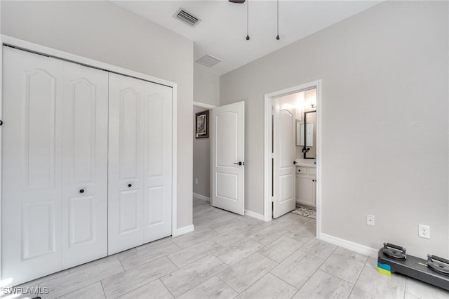 unfurnished bedroom featuring ensuite bath, a closet, and ceiling fan