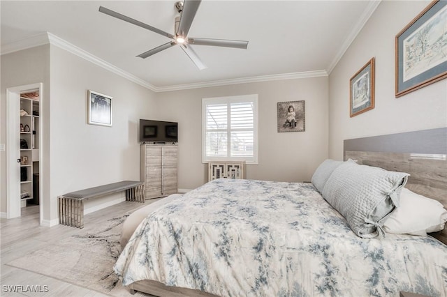 bedroom featuring crown molding, a spacious closet, and ceiling fan