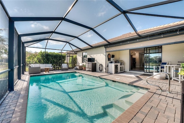 view of swimming pool featuring area for grilling, a patio, an outdoor hangout area, and glass enclosure