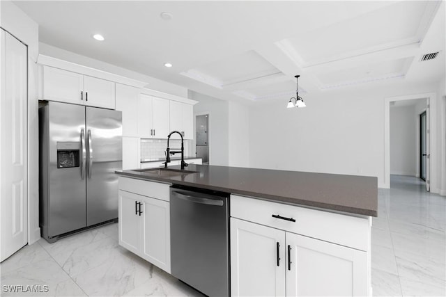 kitchen featuring white cabinets, stainless steel appliances, a kitchen island with sink, and tasteful backsplash