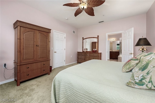 carpeted bedroom with ensuite bathroom and ceiling fan