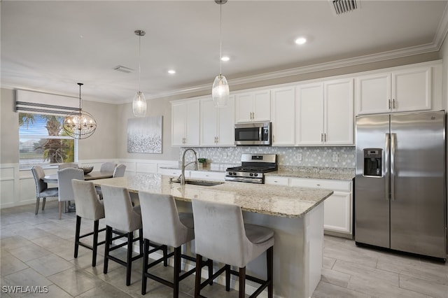 kitchen featuring stainless steel appliances, a kitchen island with sink, sink, and white cabinets