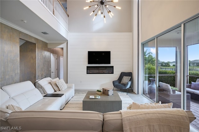 living room featuring a towering ceiling, wooden walls, and a notable chandelier