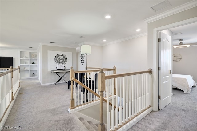 hallway featuring crown molding, light colored carpet, and built in features