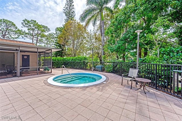 view of pool featuring an in ground hot tub, a sunroom, and a patio area