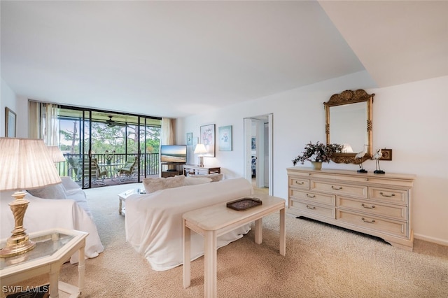 bedroom featuring access to outside, expansive windows, and light carpet