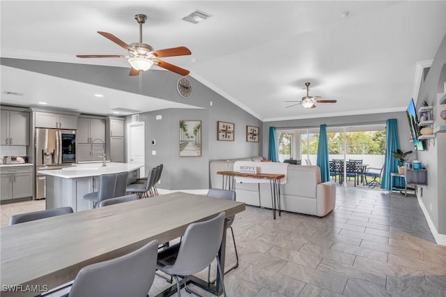 dining space with crown molding, ceiling fan, lofted ceiling, and sink