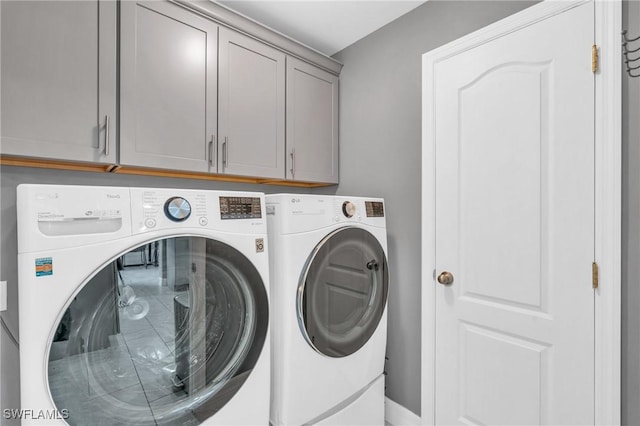 washroom with cabinets and washer and dryer