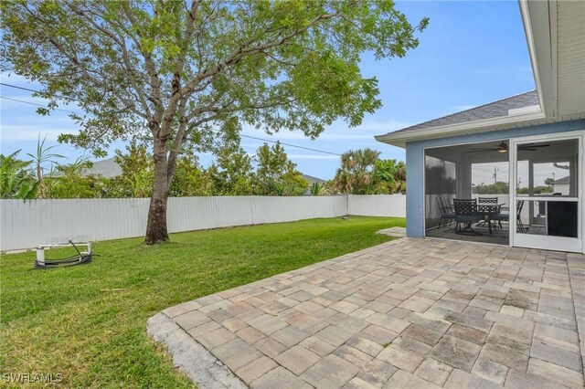 view of yard featuring ceiling fan and a patio