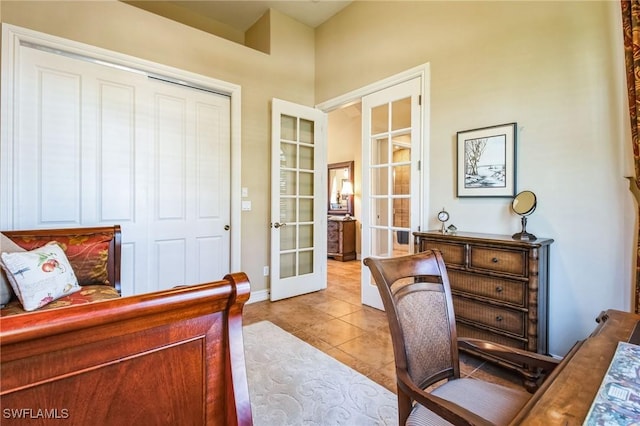 tiled bedroom with a closet and french doors