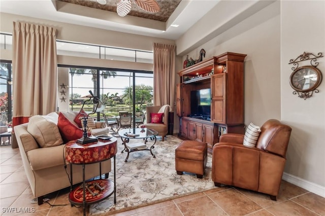 living room with a raised ceiling and light tile patterned flooring