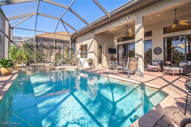 view of swimming pool with a hot tub, a lanai, ceiling fan, and a patio area