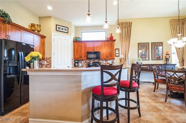 kitchen with pendant lighting, backsplash, an inviting chandelier, and black appliances