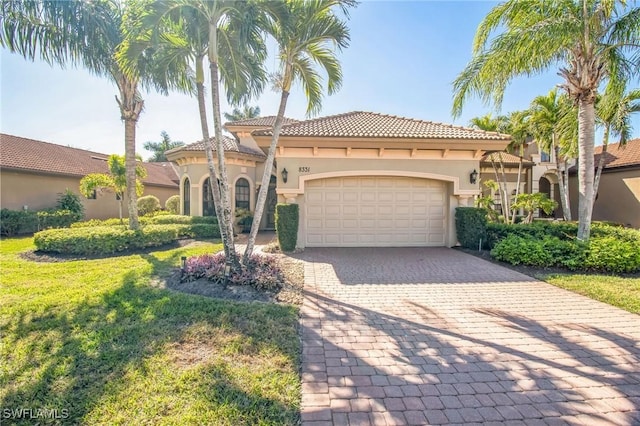 mediterranean / spanish home with a garage and a front yard